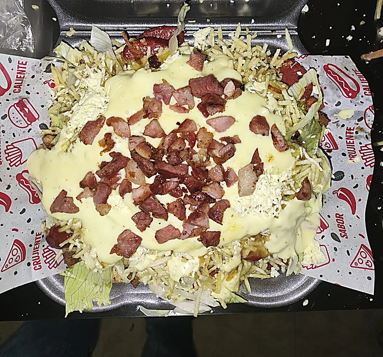 Salchipapa con tocineta y salsa en caja de icopor