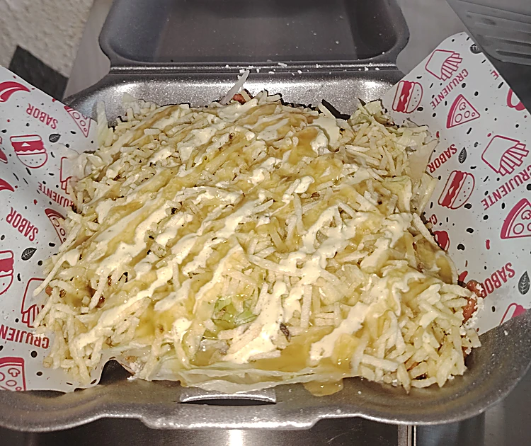 Salchipapa cubierta de queso rallado en caja de icopor